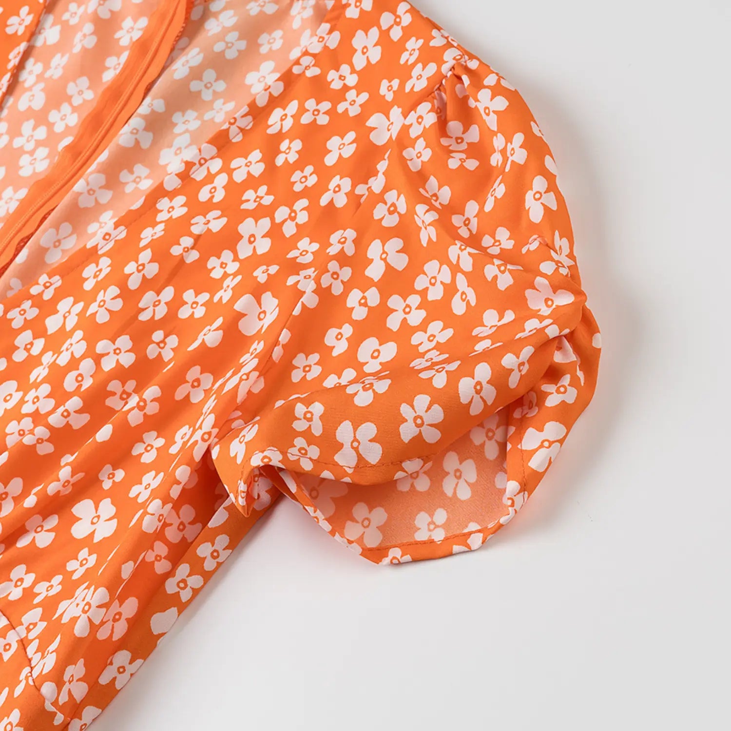 Close-up of the puff sleeve construction and finished cuff on the orange floral dress