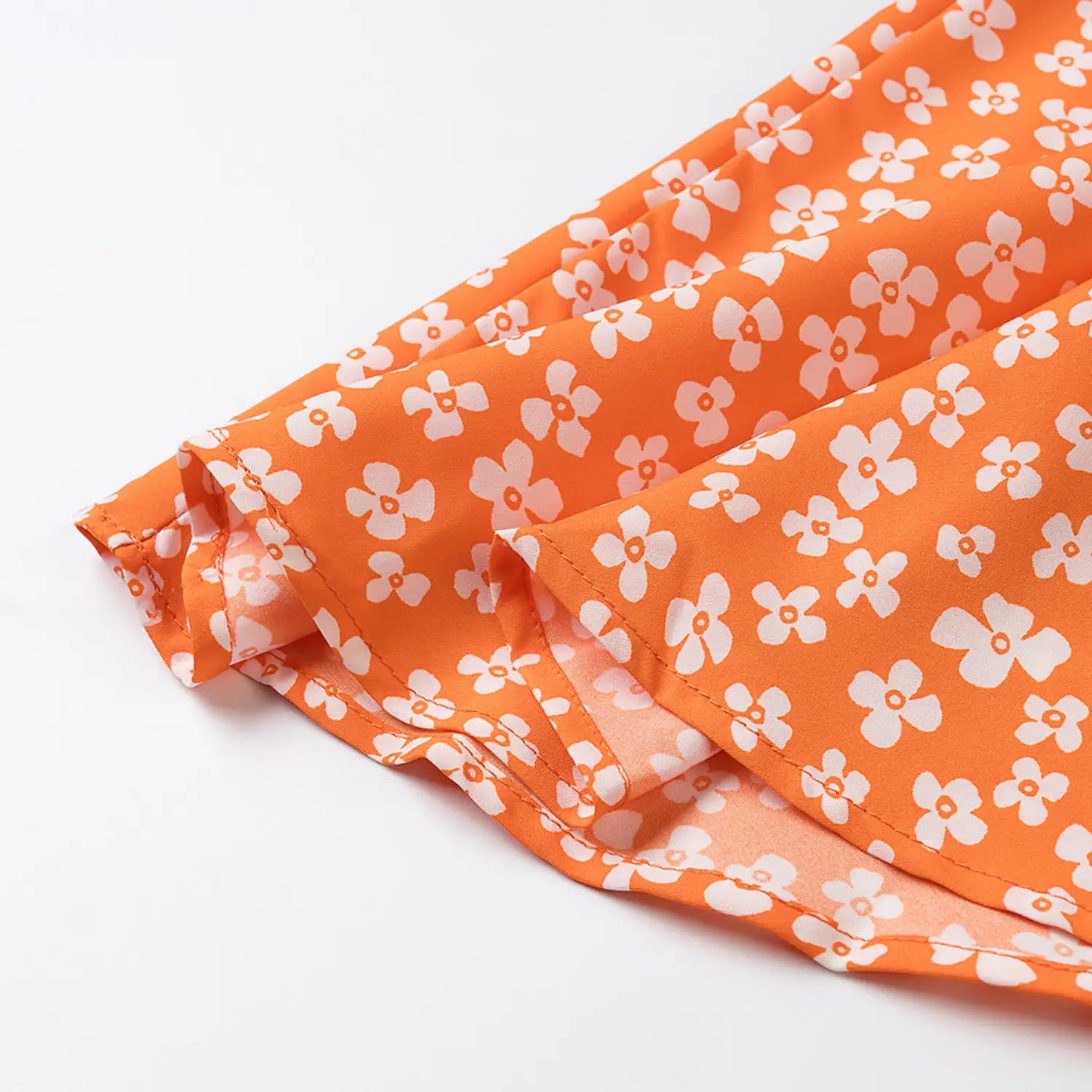 Close-up of the finished hem and double stitching on the orange floral dress
