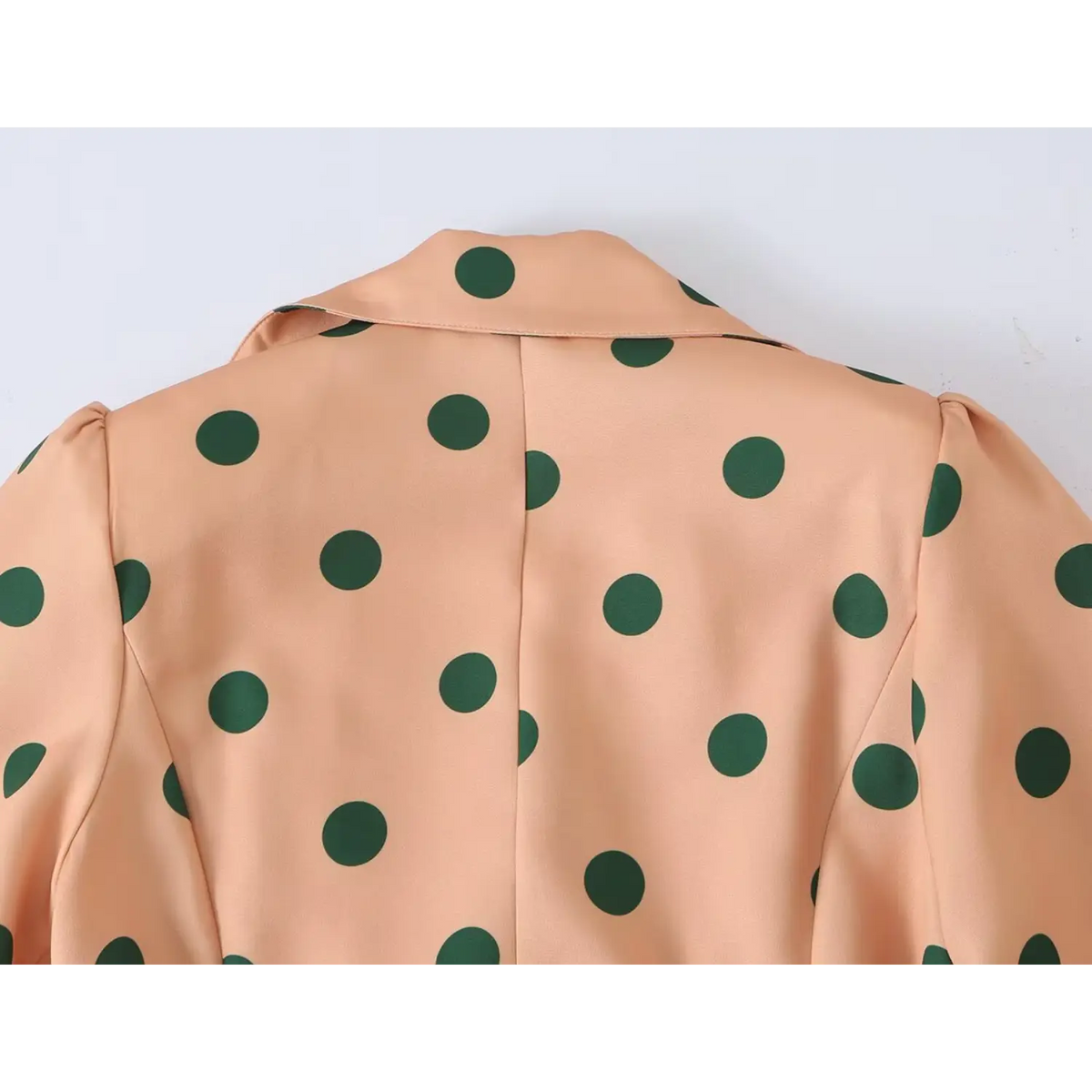 Back view of women orange polka dot trench coat, lapel collar and puff shoulder design