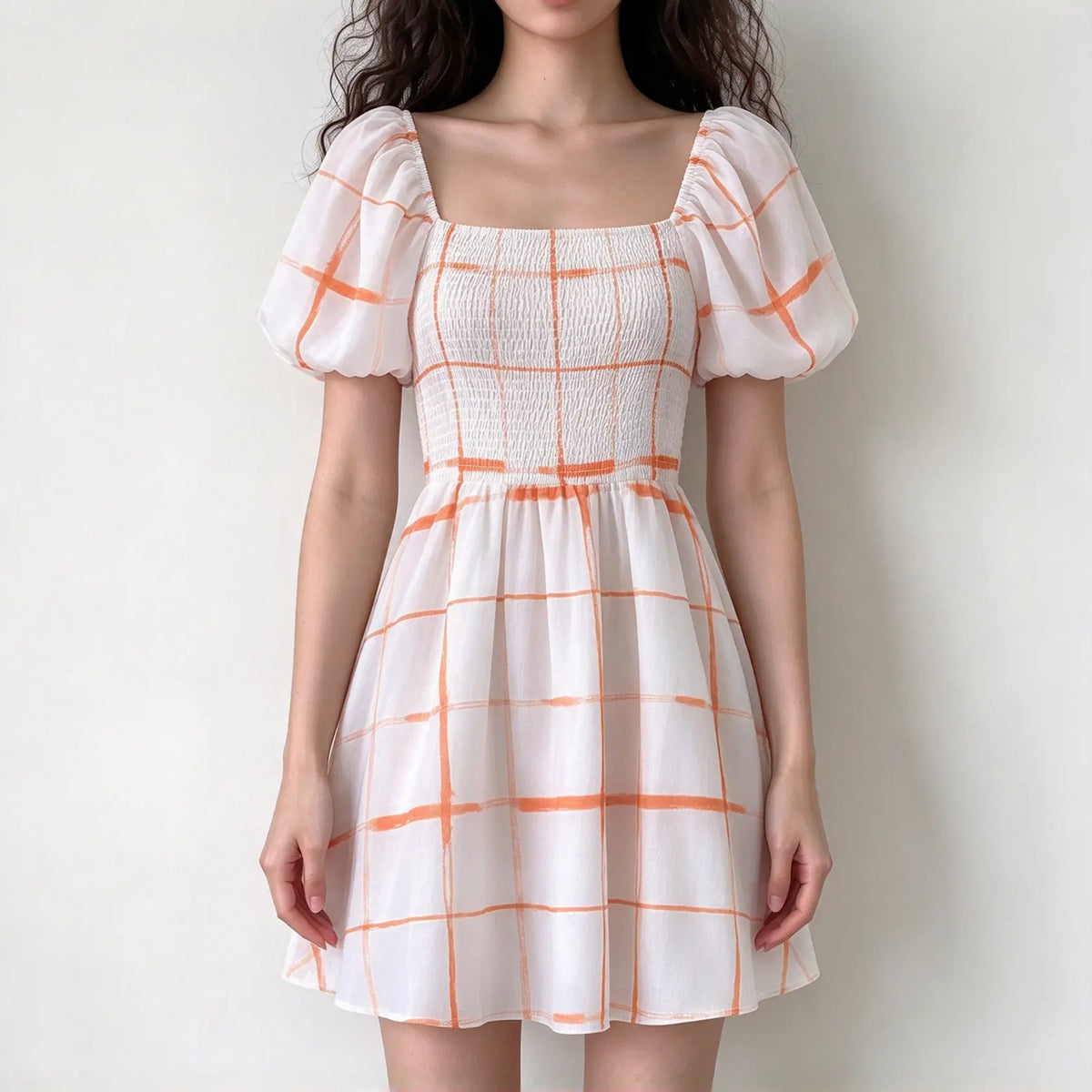 Model wearing orange grid print square neck smocked puff sleeve mini dress, front view