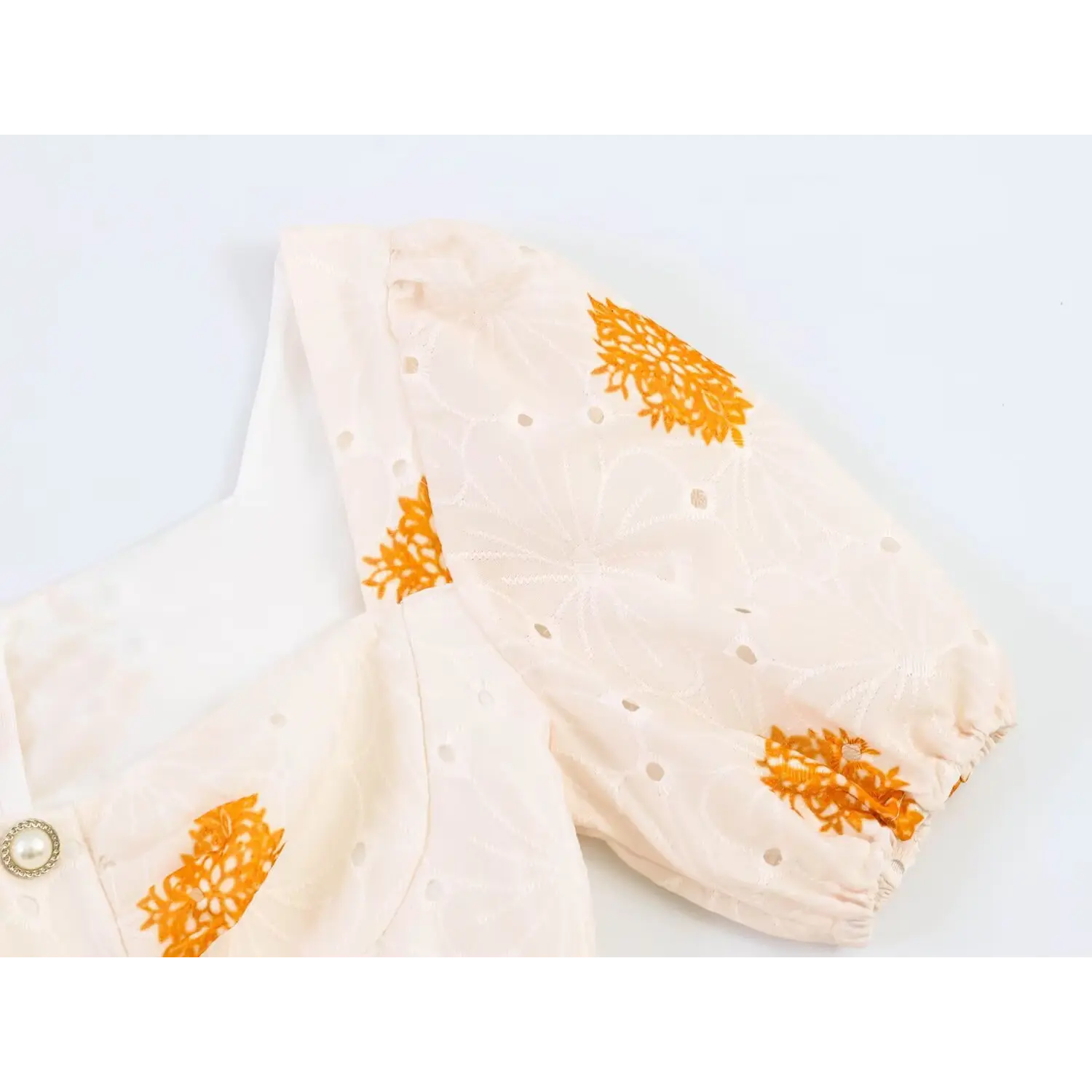 Detailed shot of elasticated puff short sleeve with eyelet cutwork and vintage paisley print