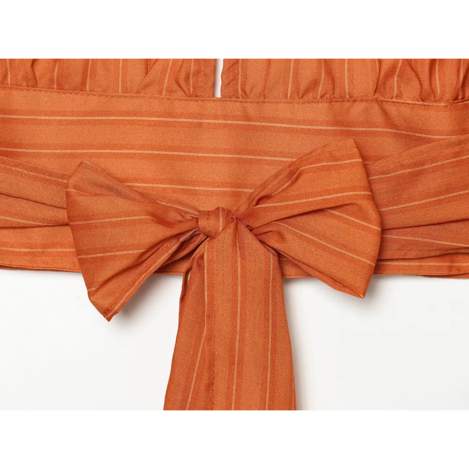 Back overview shot orange stripe halter cropped top, large fabric bow tie knot at waist back