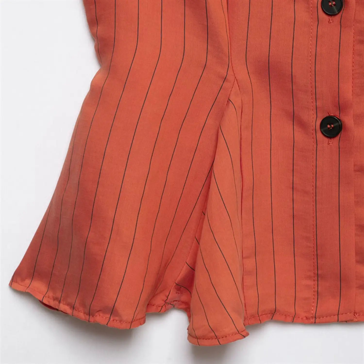 Front peplum hem close-up, flared ruffled edge, hem stitching, natural fabric fold, stripe pattern along hemline
