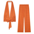 Flat lay orange vertical stripe two piece set, deep v halter tie‑back top and elastic waist wide leg trousers