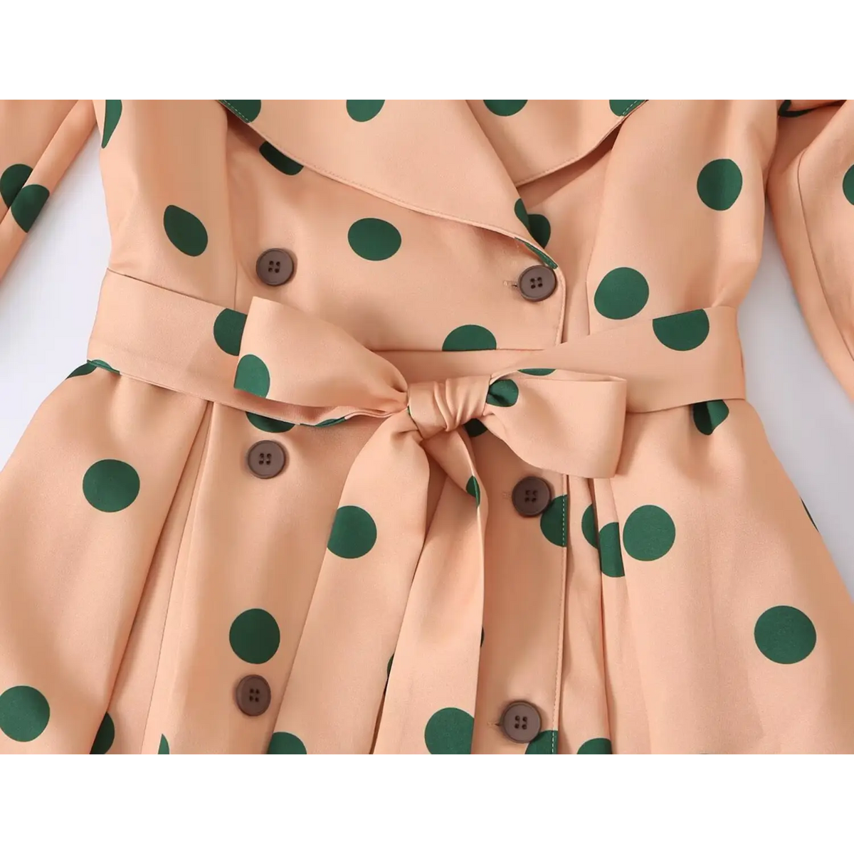 Hem detail view of orange long windbreaker trench coat
