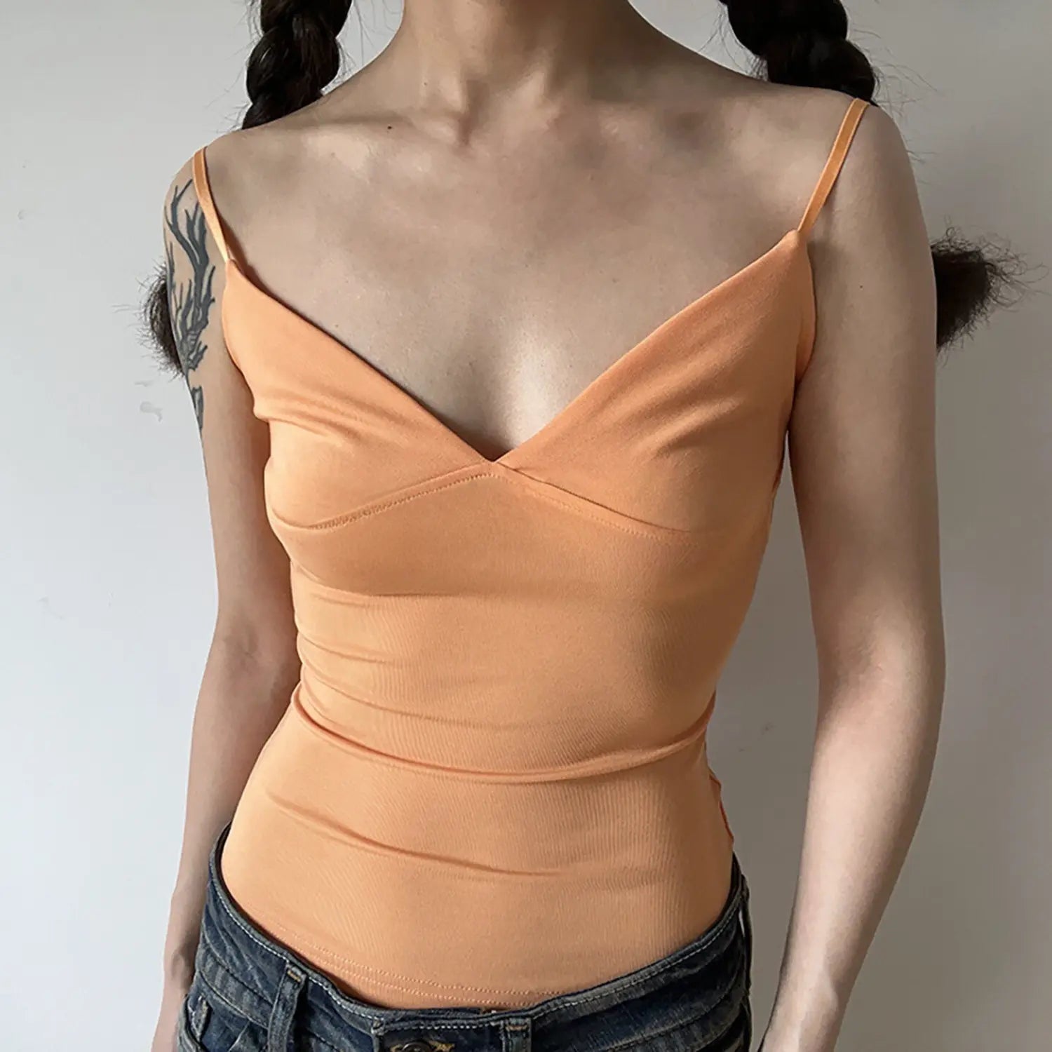 Studio front view of apricot orange deep V camisole tank top, stretch ribbed fabric, fitted waist ruched design thin straps women basic inner top