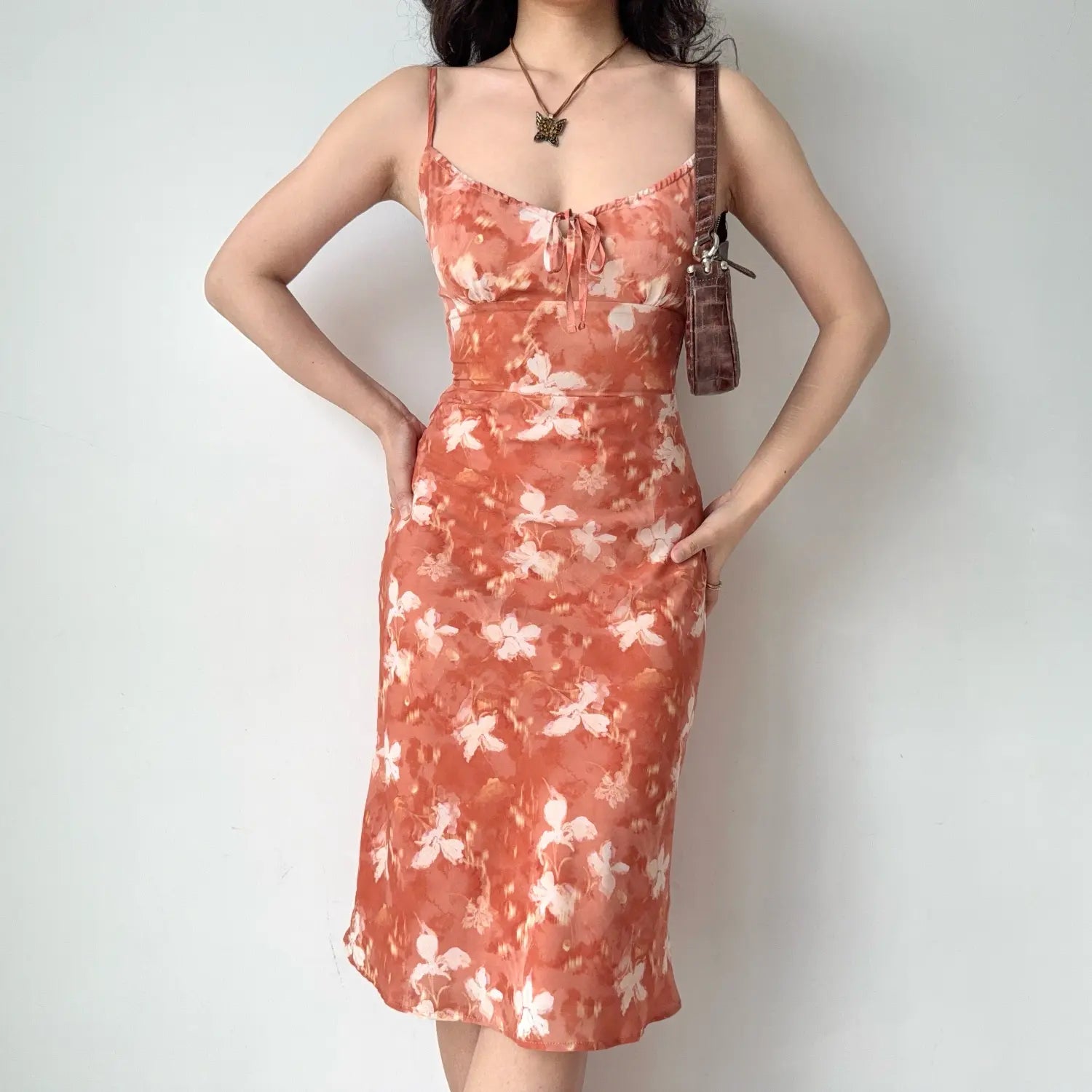 Front view outfit photo of the floral slip dress, hands resting on hips to show fitted waist silhouette