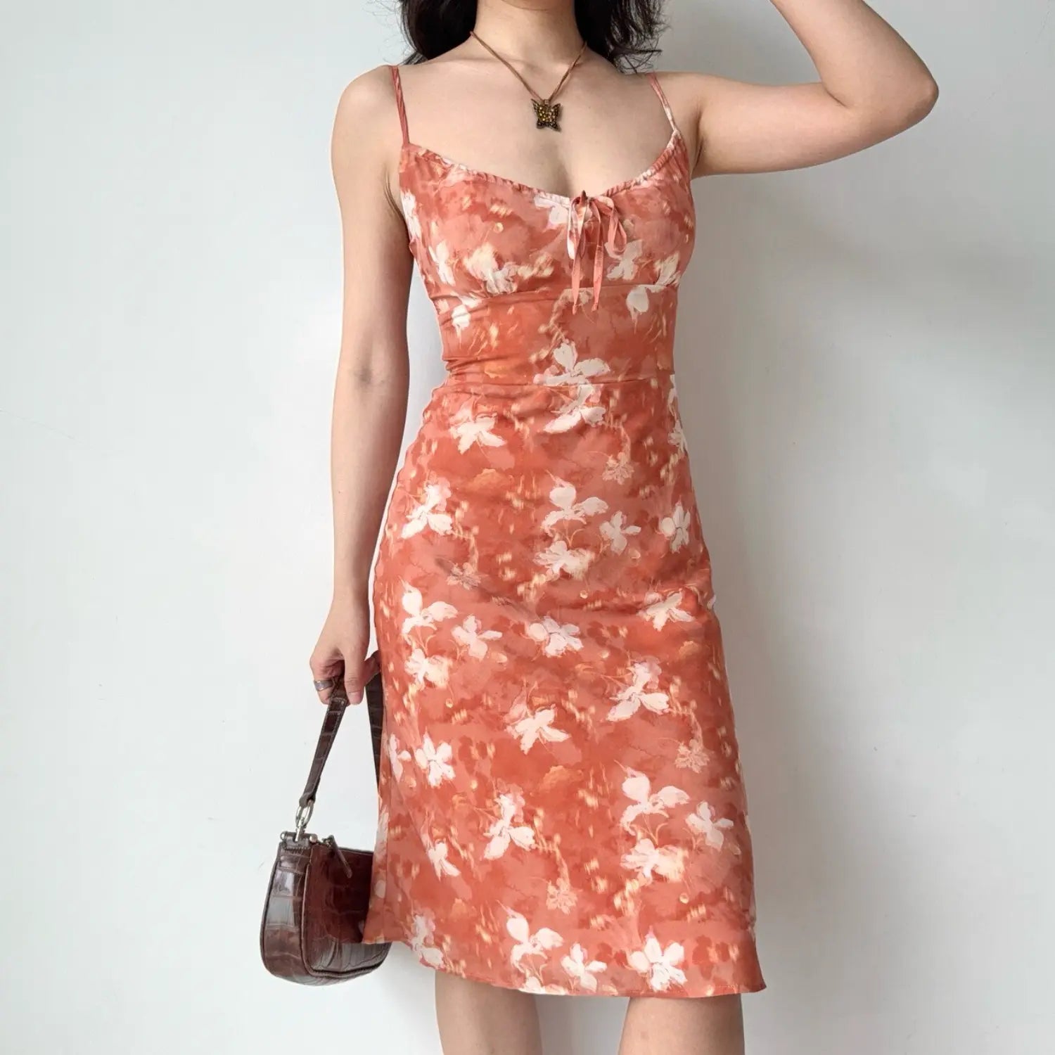 Three-quarter view shot, holding brown leather shoulder bag, showing the soft draped skirt fabric