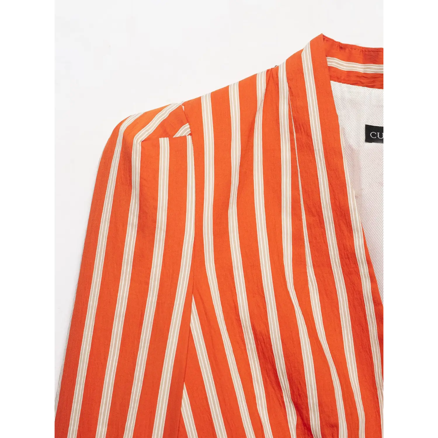 Close‑up shoulder and collar detail of orange white stripe peplum blazer