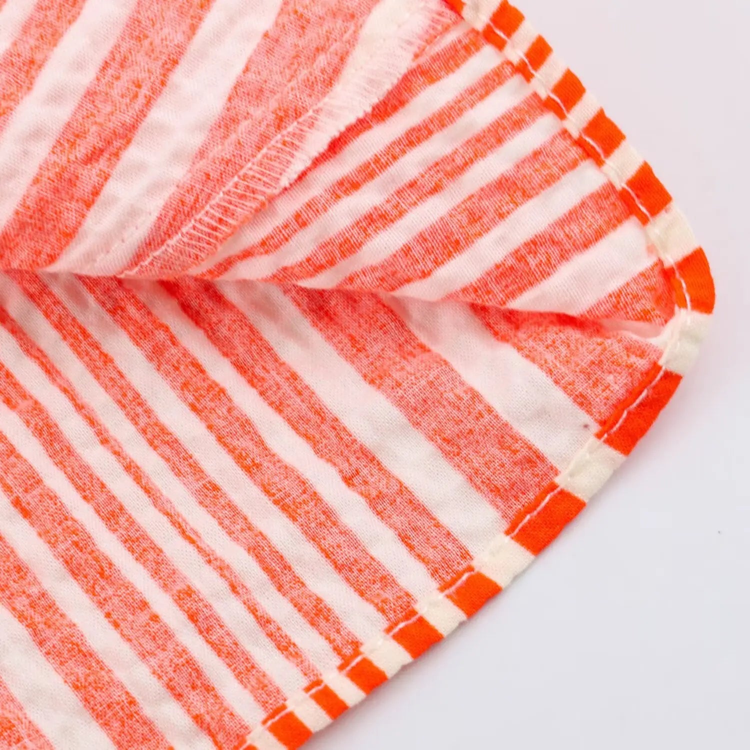Partial shot of striped fabric finished seam and hem detail
