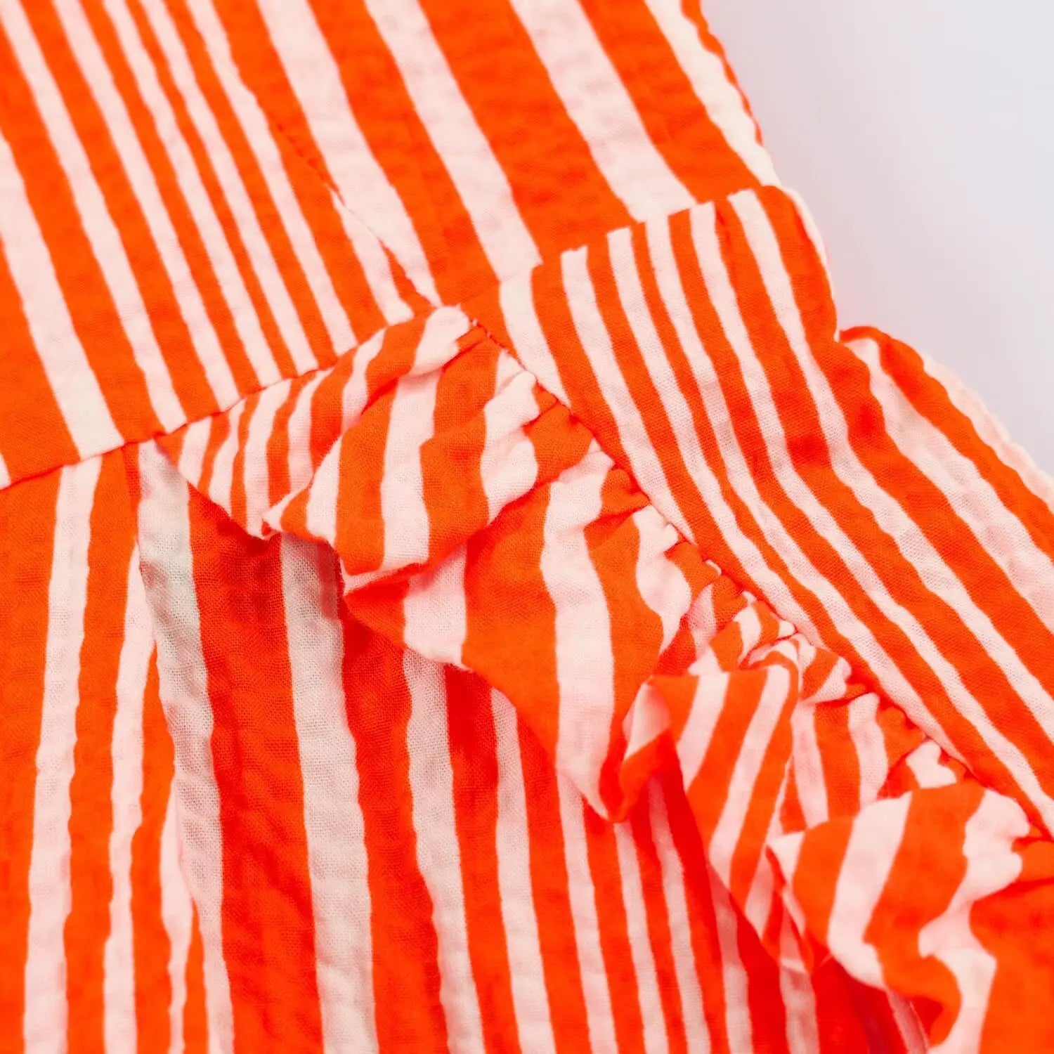 Partial close‑up of side pocket stitching on striped maxi dress