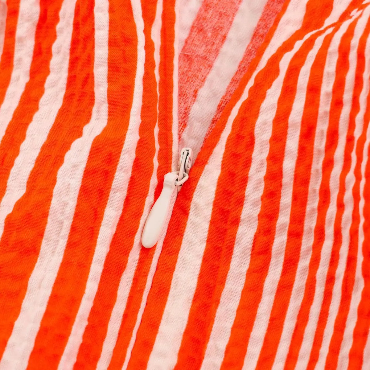 Macro close‑up of hidden side zipper on striped dress