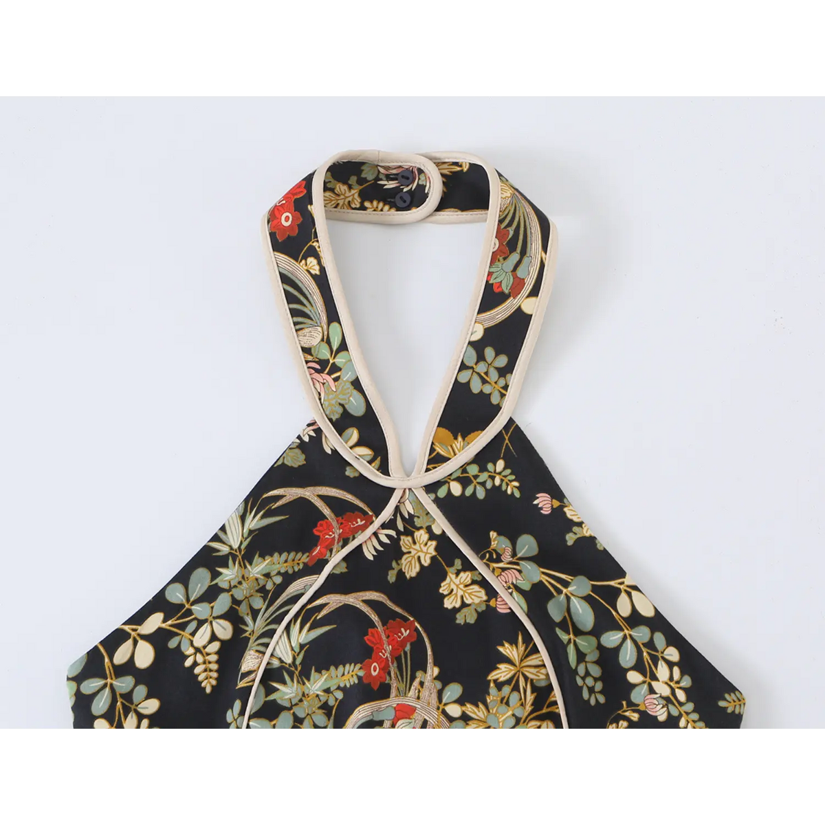 Close-up of halter neckline with contrast piping on oriental floral dress