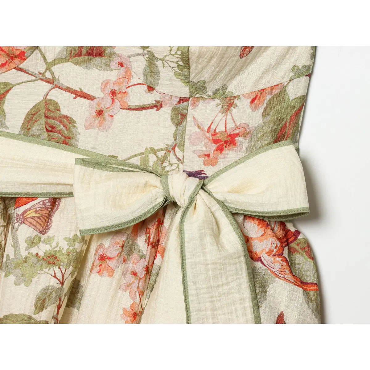 Waist bow detail of cottagecore sundress, wide matching printed belt knotted into big side bow with green piped edge finishing.