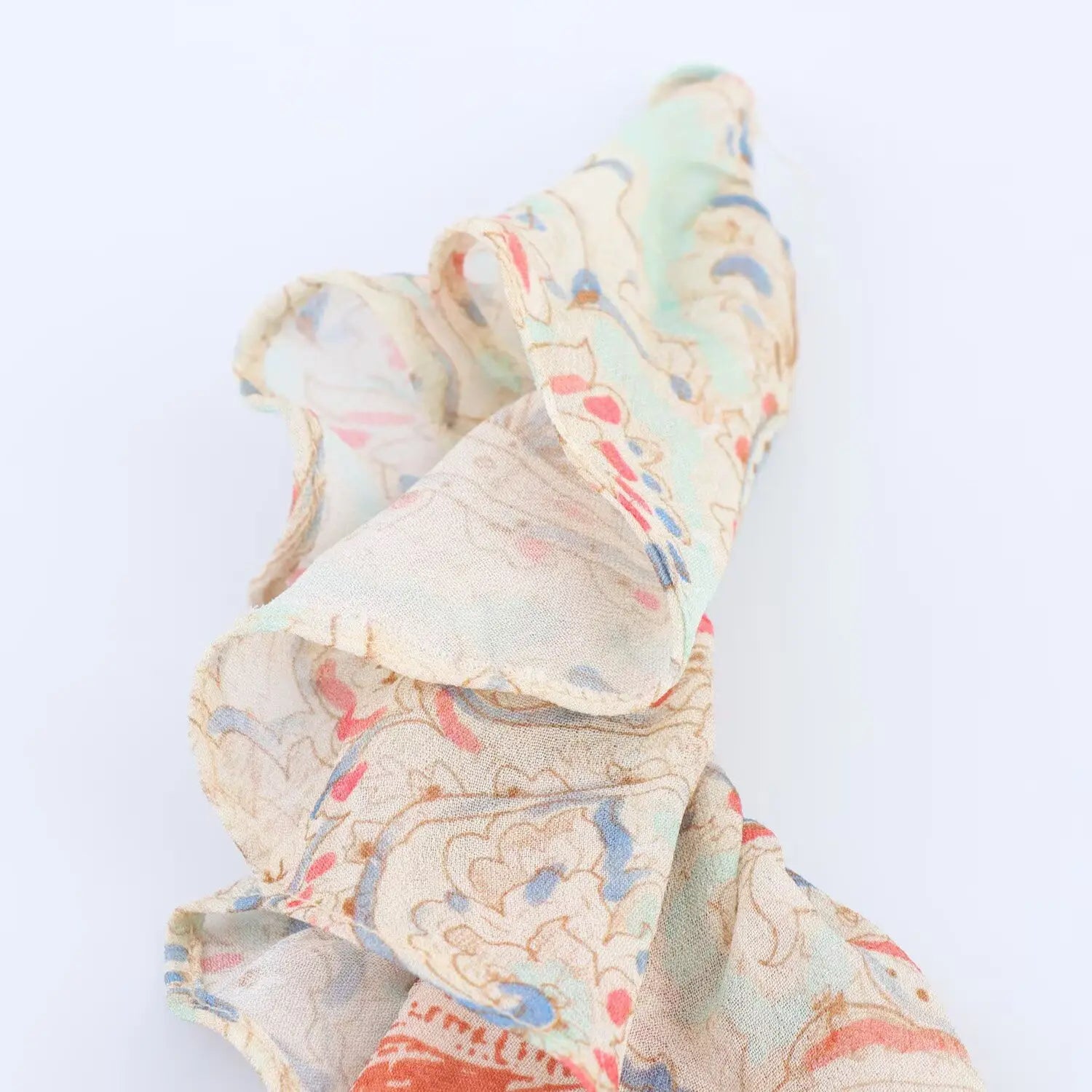 Macro close‑up of lightweight chiffon ruffle fabric, soft semi‑sheer texture with vintage paisley print