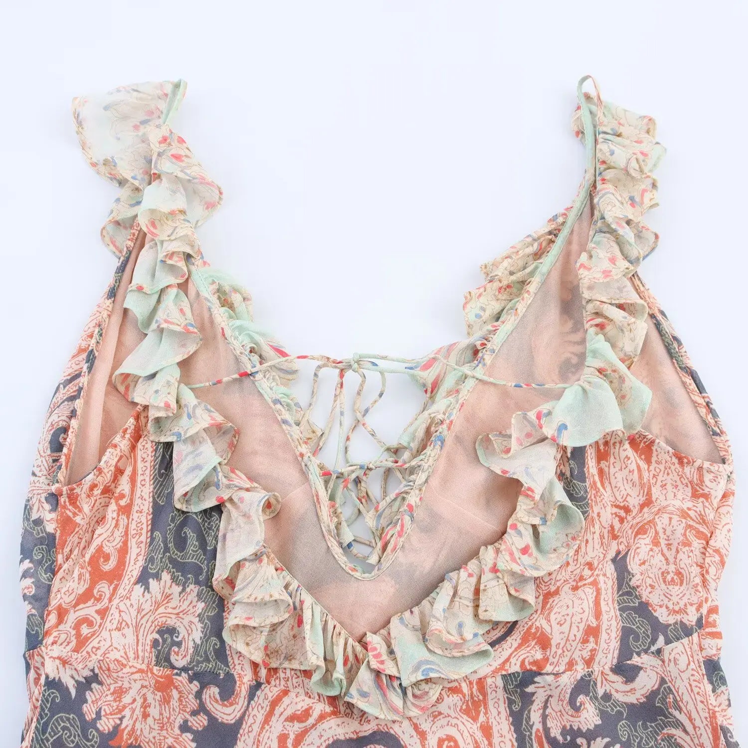 Inside close‑up of back bodice, crisscross lace‑up ties, ruffle trim, solid lining fabric