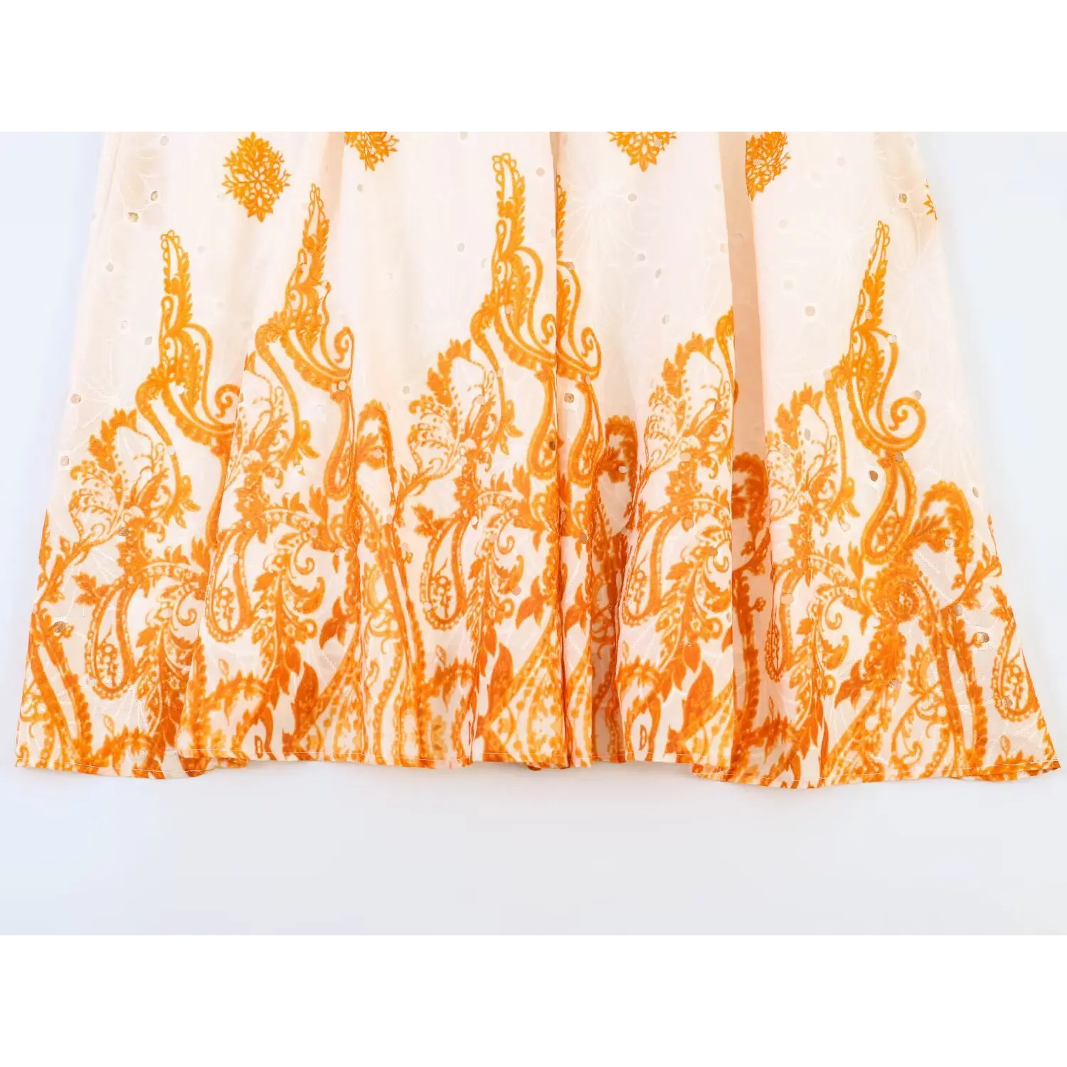 Close-up of long maxi dress hem, neat stitching and flowy paisley print skirt edge