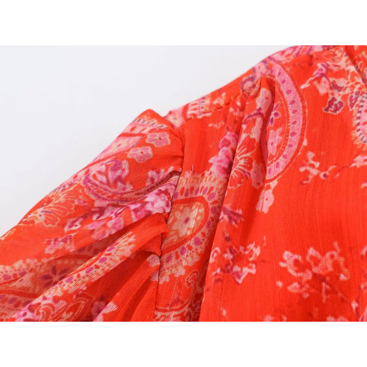 Macro shot of lightweight flowy fabric of paisley maxi dress, showcasing semi-sheer texture and print