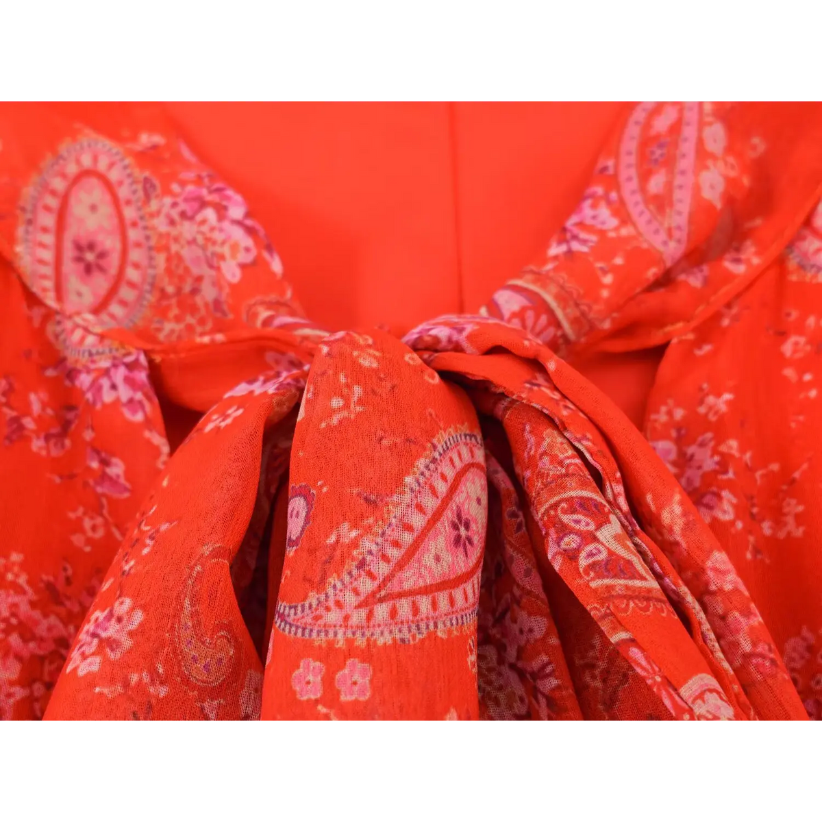 Detailed shot of front neck tie knot on paisley maxi dress, layered lightweight fabric and paisley motif
