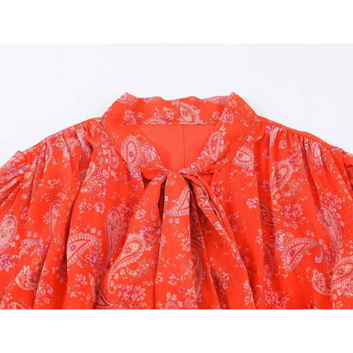 Close-up of tie neck collar on paisley print maxi dress, red base with pink paisley and floral pattern