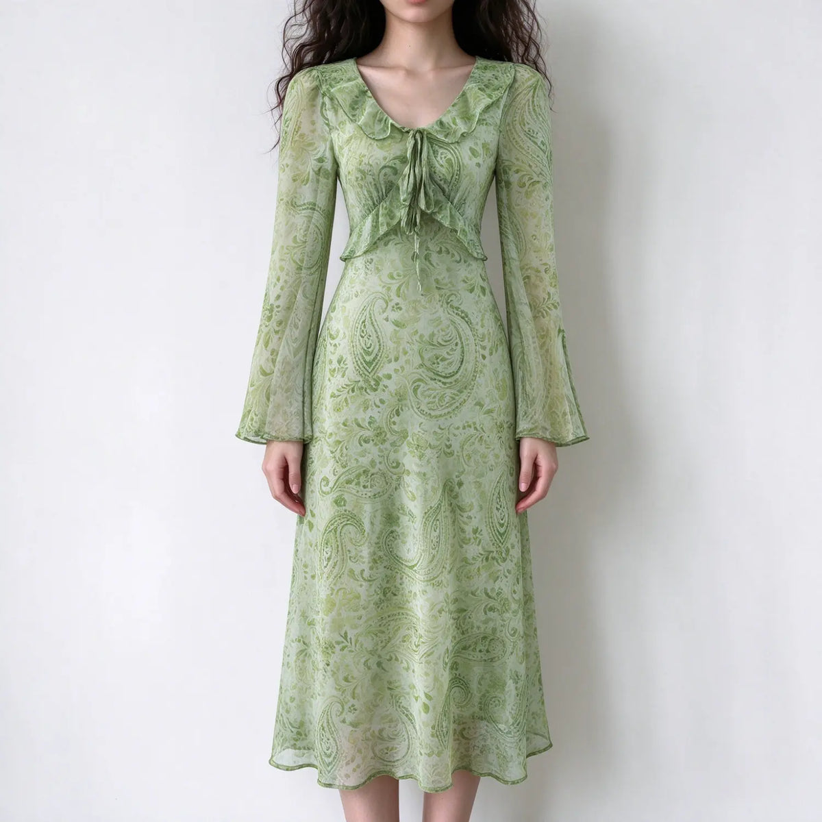 Model wearing paisley print ruffle tie bell sleeve midi dress, front view