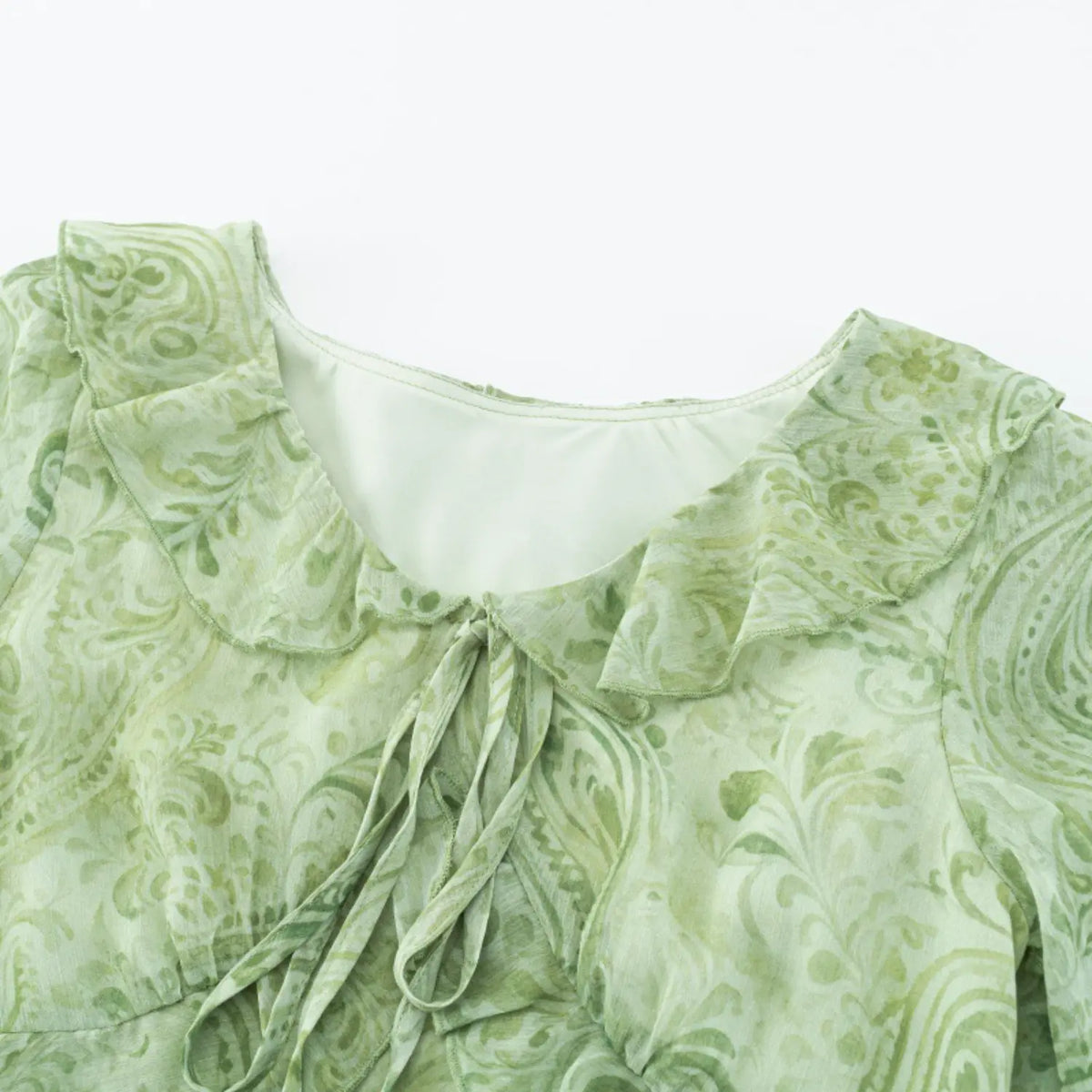 Close-up of ruffle V-neck and tie