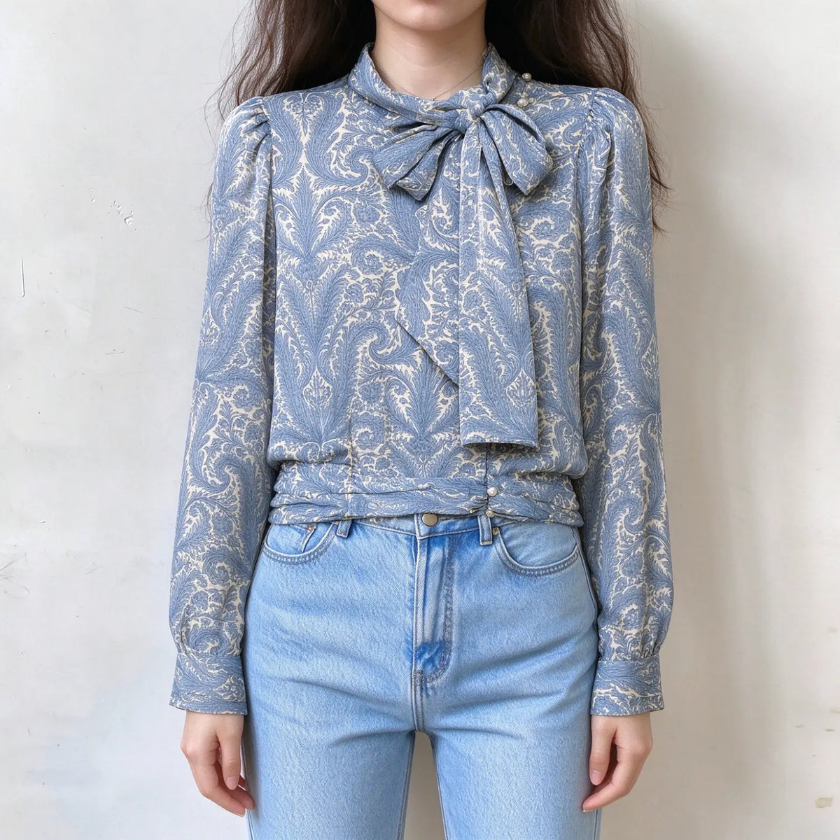 Model wearing paisley print tie neck blouse, front view
