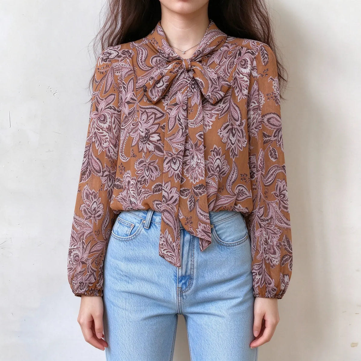Model wearing paisley print tie neck puff sleeve blouse, front view