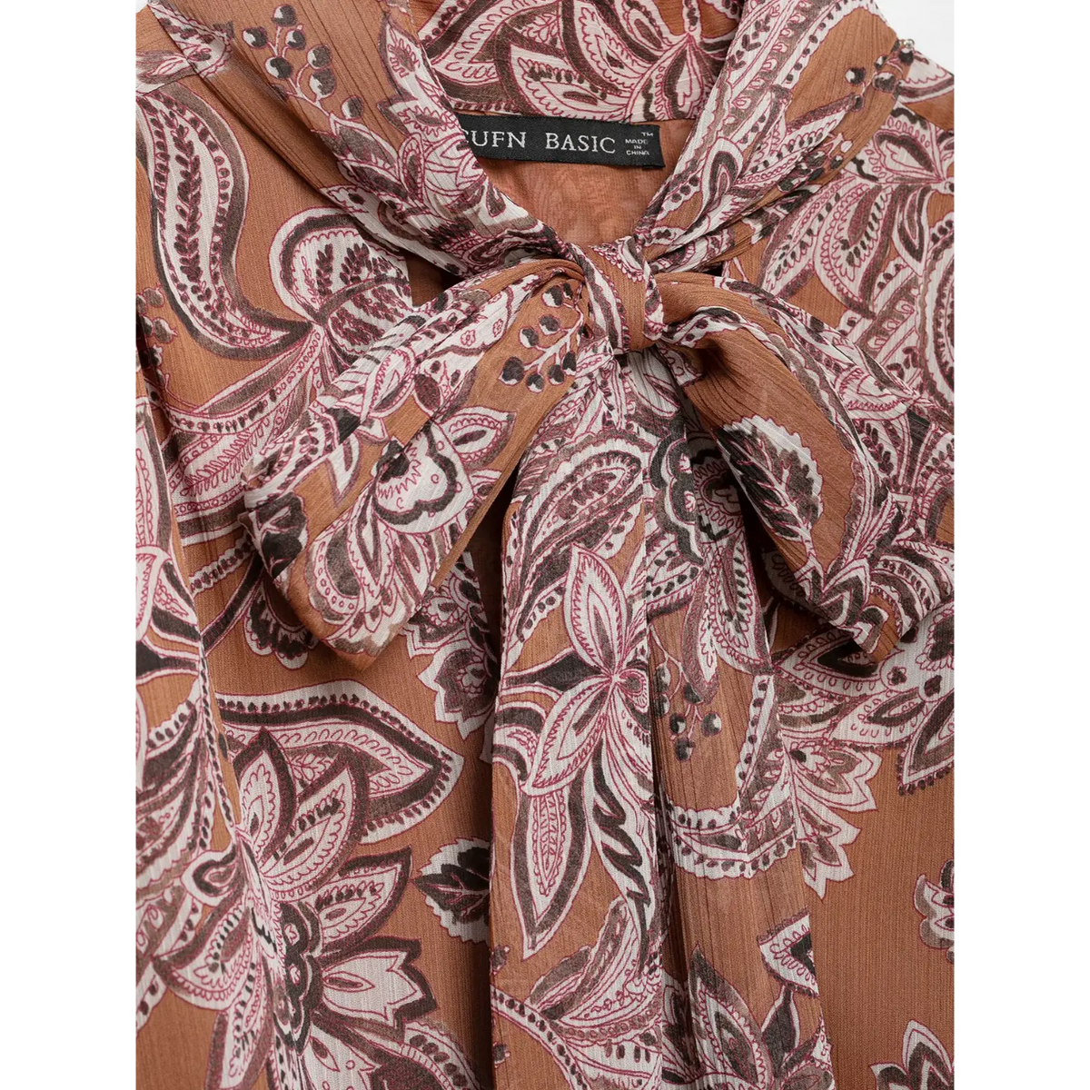 Close-up of tie neck bow and woven label