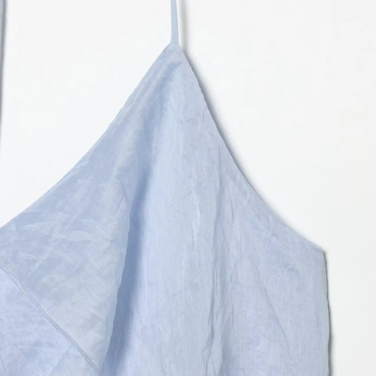 Fabric macro shot of light blue halter dress, subtle glossy crinkled woven material texture