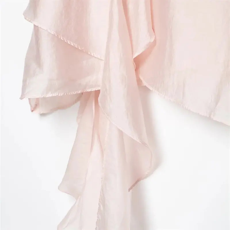 Long drape ruffle tail hem closeup, folded narrow finished edge, natural soft drape satin texture
