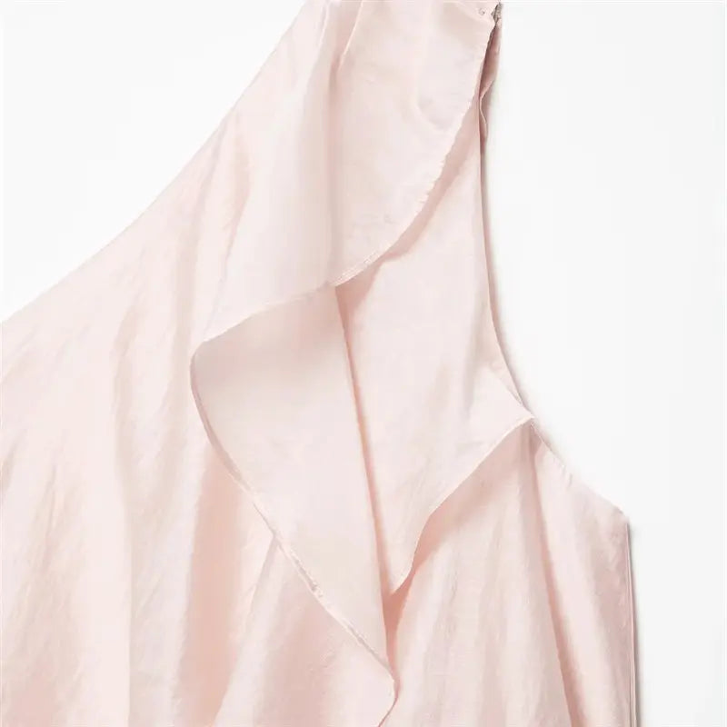 Macro closeup asymmetrical diagonal single shoulder neck, layered waterfall ruffle drape, fine folded edge stitching, lustrous pale pink satin texture