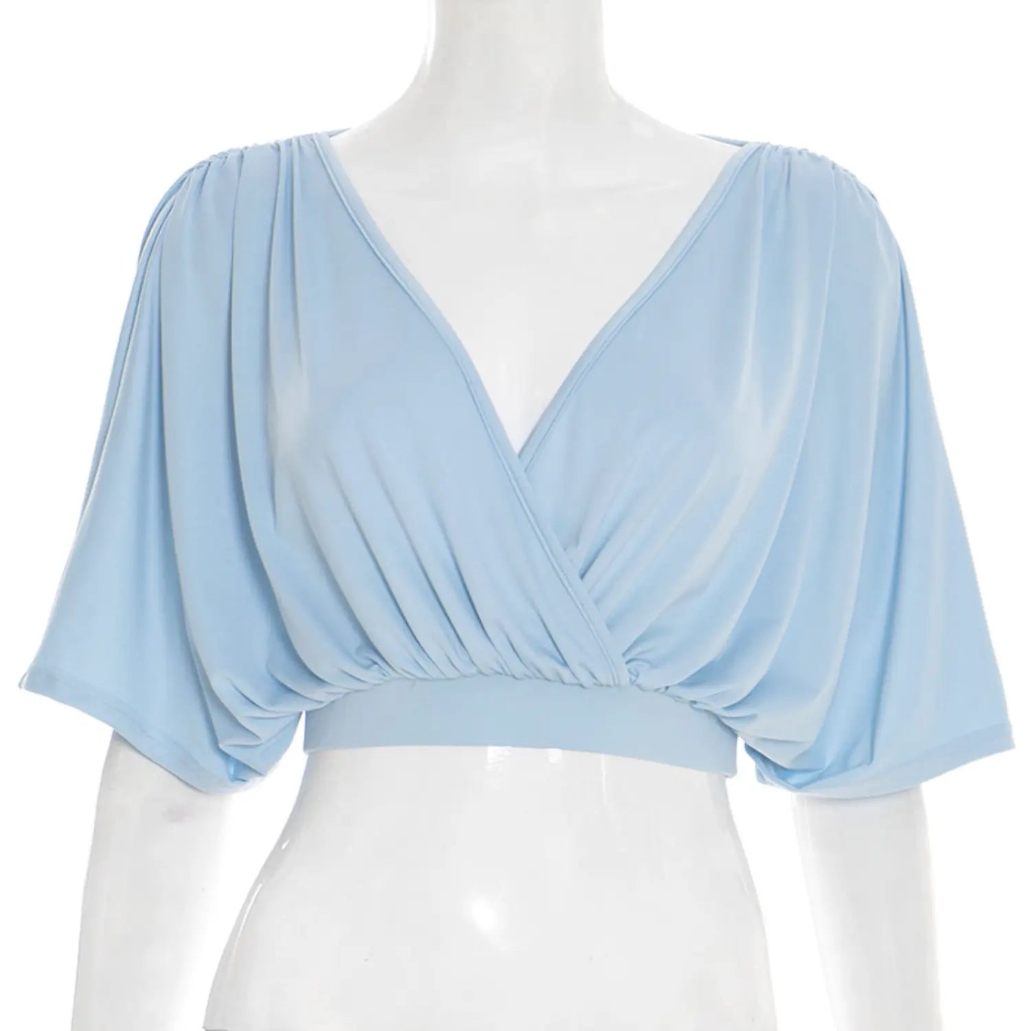 Full front white studio mannequin hero shot of wrap front crop top, solid sky blue lightweight stretch jersey, deep V surplice neckline, shoulder & front waist gathered ruching, oversized flowy dolman short sleeves, fitted elastic cropped waist