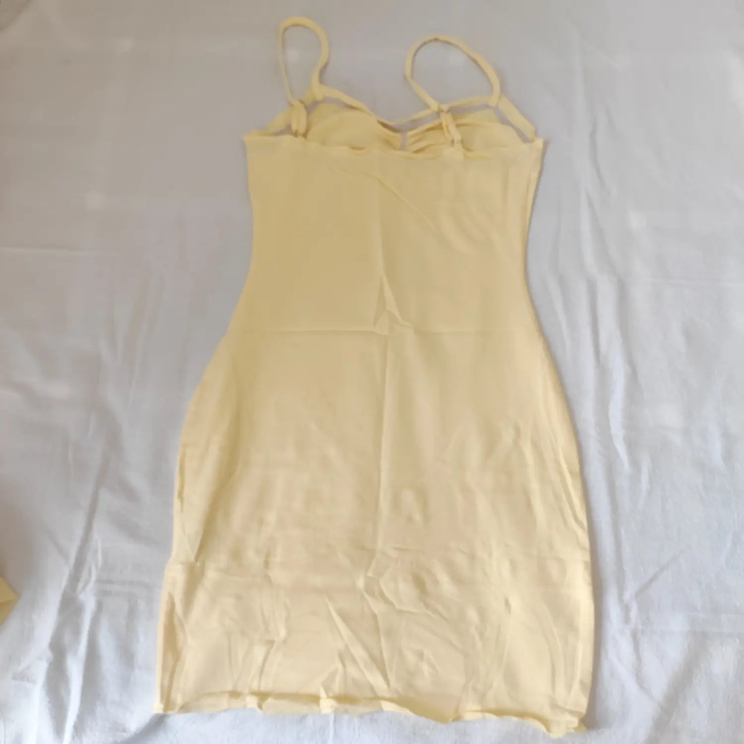 Flat lay back view light yellow ruched bust spaghetti strap mini dress