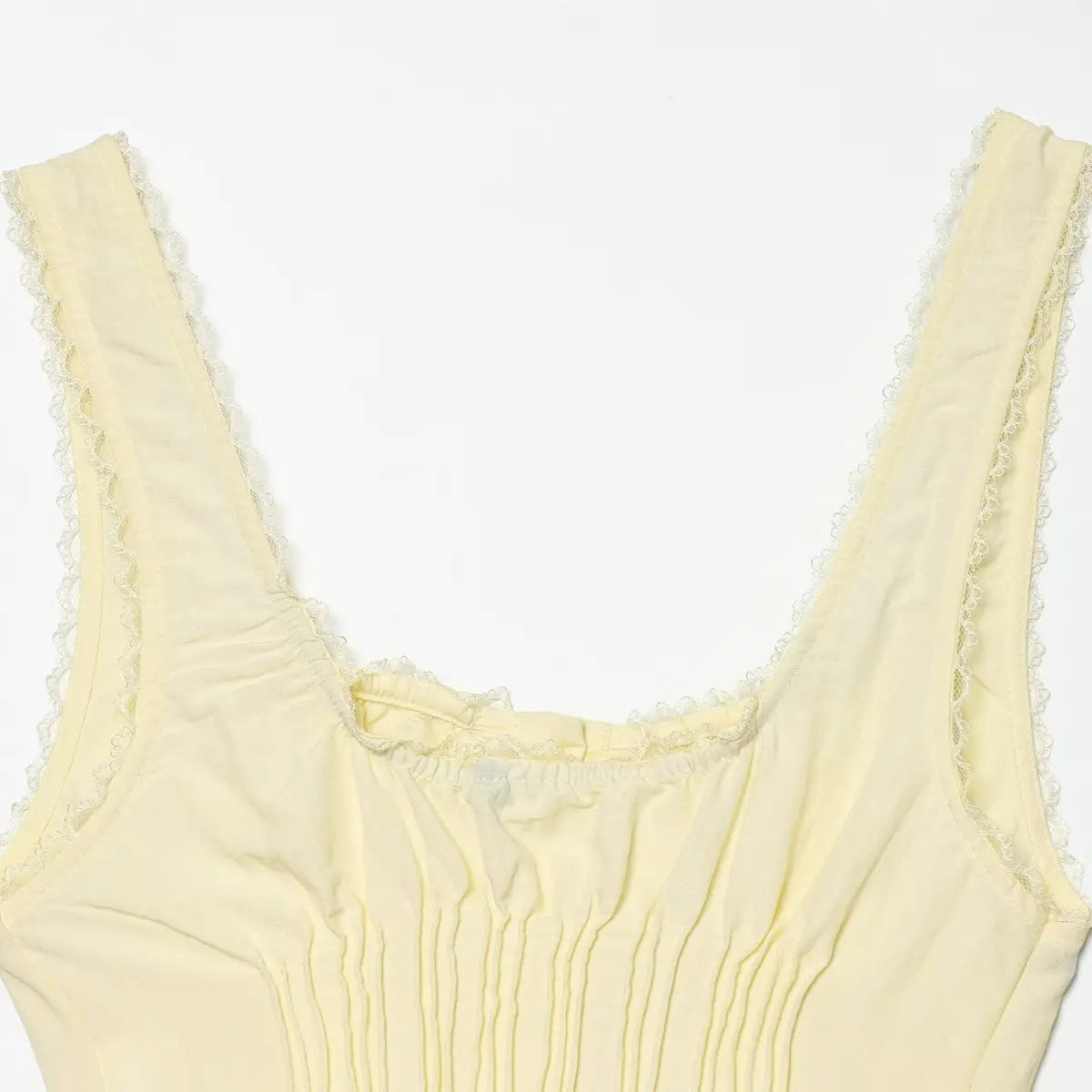 Back view of the pale yellow corset-style cami top, showing the square neckline, lace trim, and pleated bodice