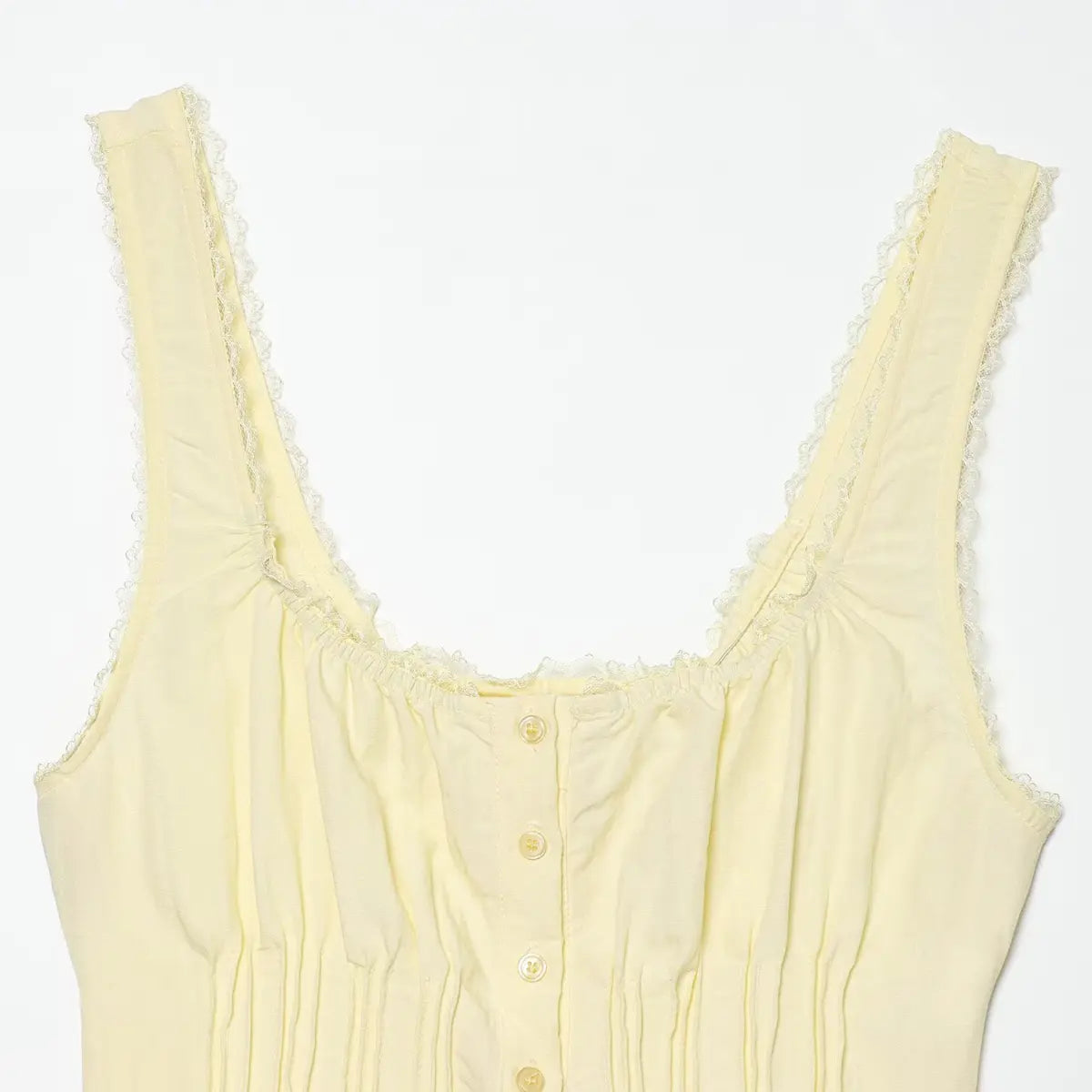 Close-up of the lace-trimmed square neckline on the pale yellow cami top, showing the gathered fabric