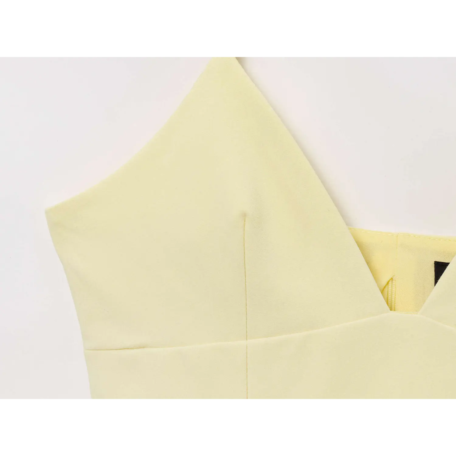 Close-up of tailored bust seam and deep V neckline on pale yellow camisole top