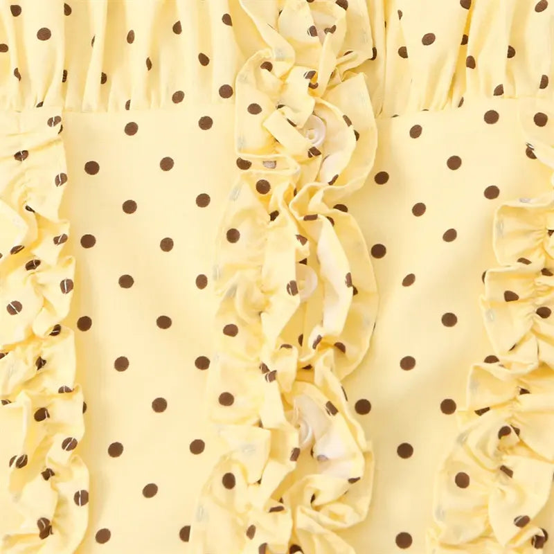 Center front ruffle placket detail, hidden round buttons layered between frill trim, polka dot print