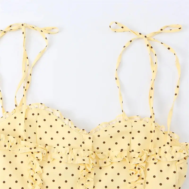 Macro shot thin tie spaghetti strap bow detail, matching pale yellow polka dot material