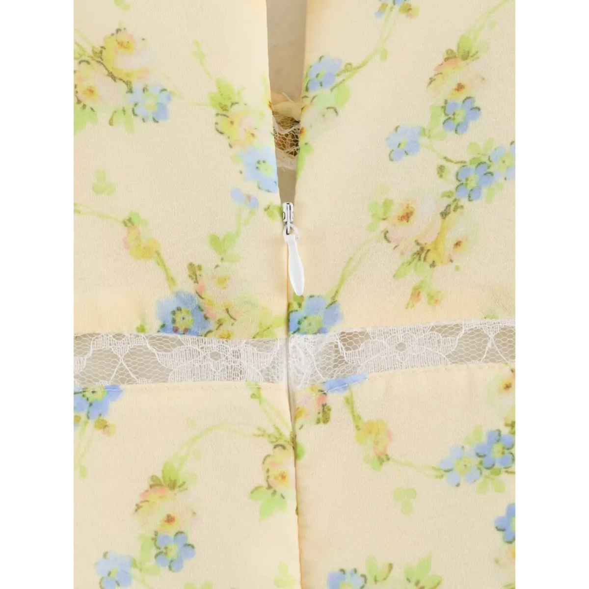 Close-up of the invisible zipper at dress back, pale yellow floral chiffon fabric paired with white lace waistband