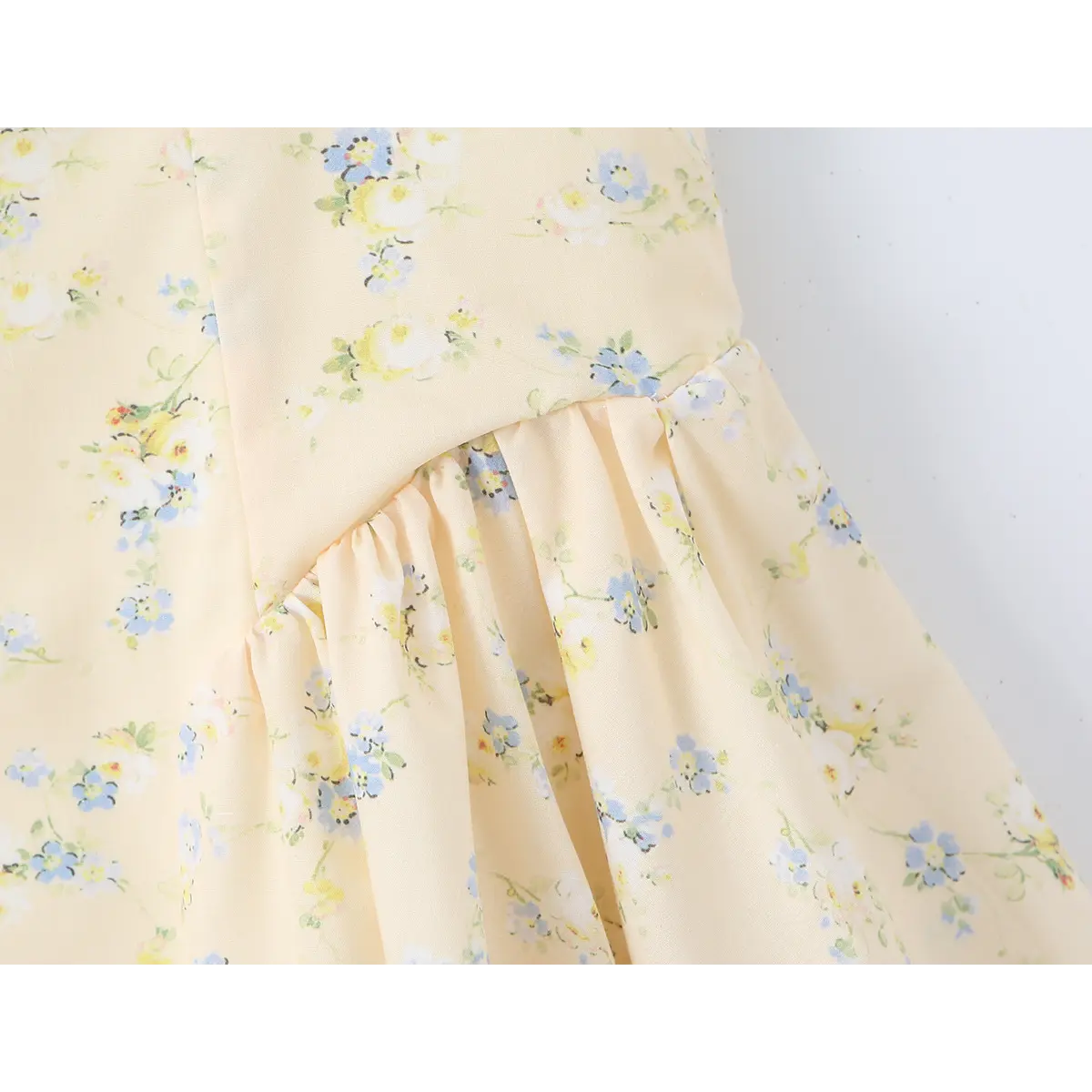 Close-up of the gathered seam at the waist, where the fitted bodice meets the flowy skirt.