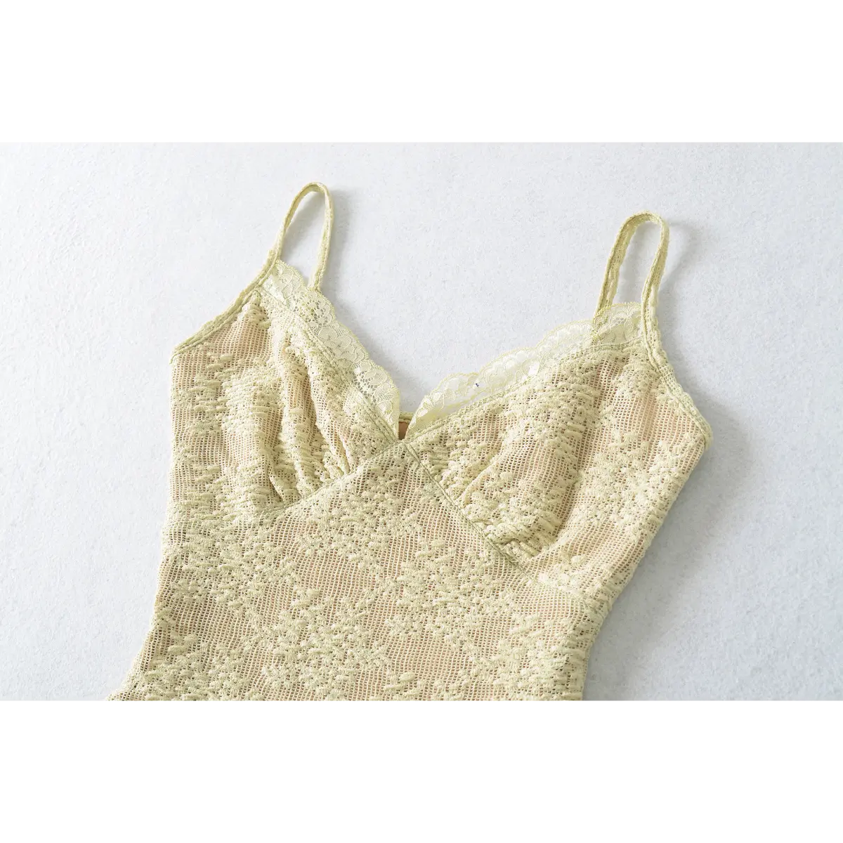 Slightly angled view of the pale yellow lace camisole, highlighting the fitted bust and lace texture.