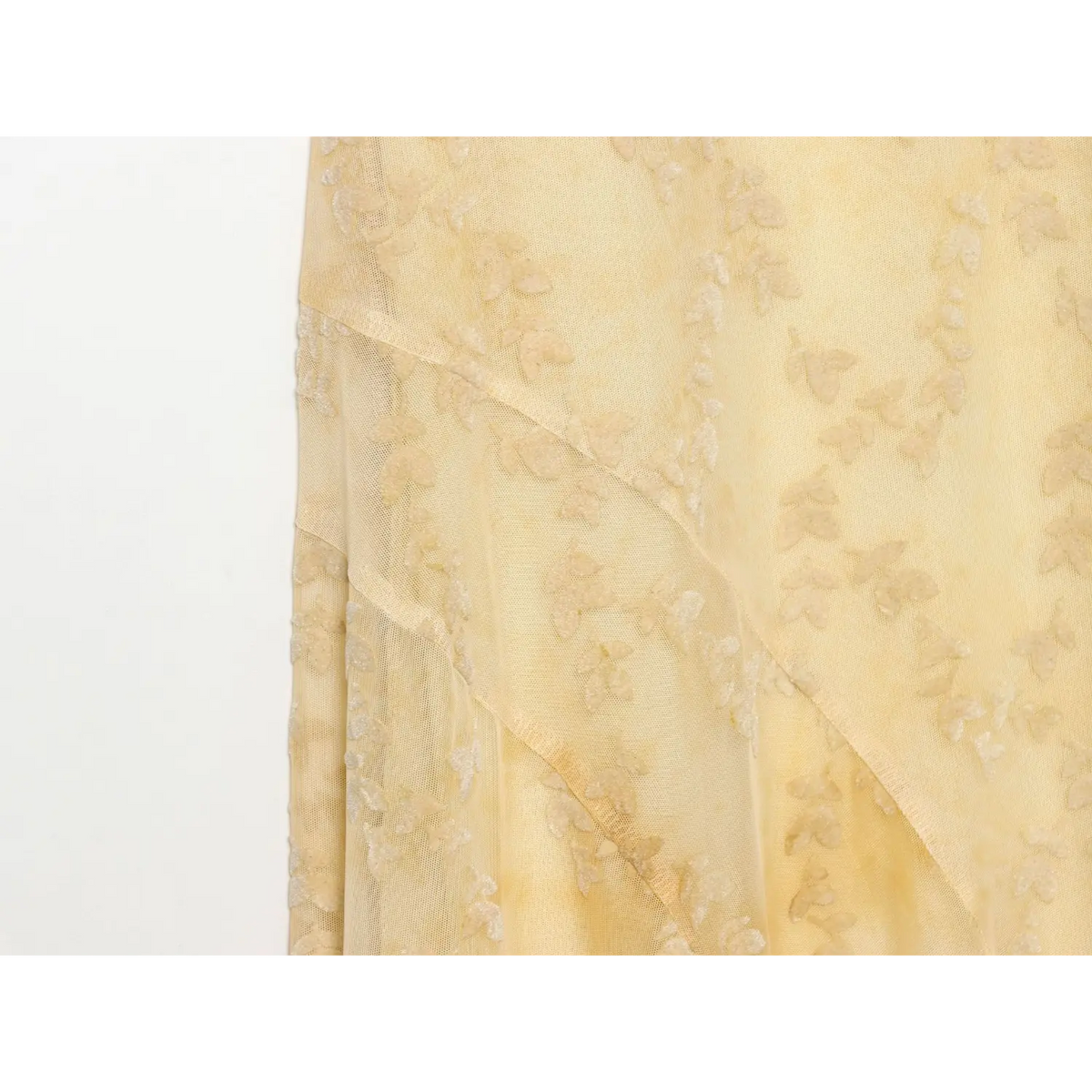 Close‑up view of pale yellow leaf jacquard mesh maxi dress, bias cut seam and flowy mesh fabric detail