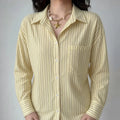 Front lifestyle shot on model of loose fit vertical stripe shirt, casual oversized silhouette, wearable open front