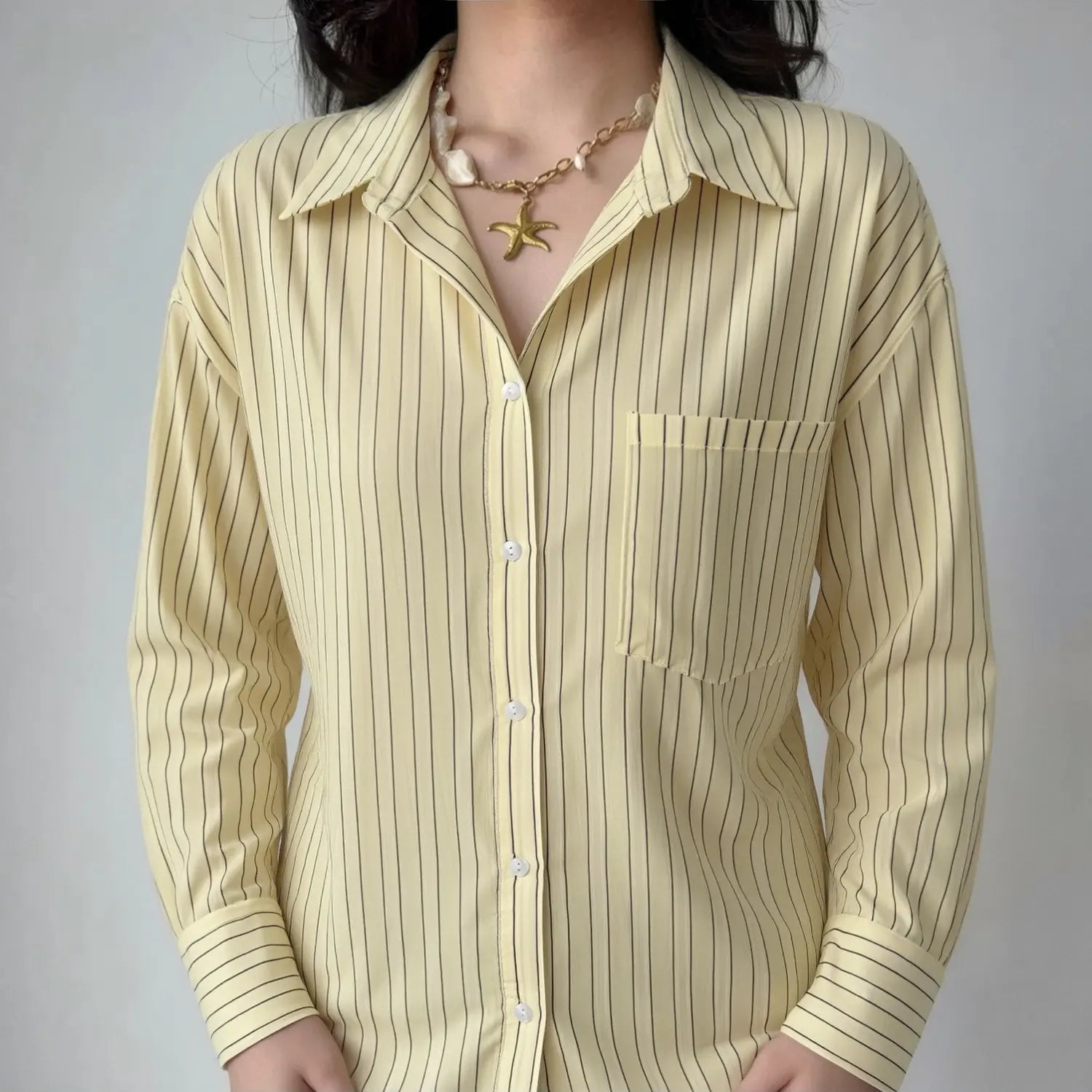 Front lifestyle shot on model of loose fit vertical stripe shirt, casual oversized silhouette, wearable open front