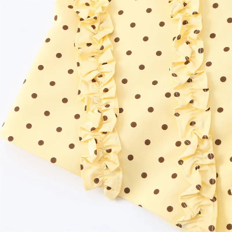 Curved jagged hem edge closeup, side ruffle trim finished seam, soft yellow dot fabric