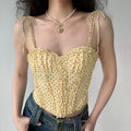 Lifestyle model shot pale yellow brown polka dot corset cami top, adjustable tie spaghetti straps, sweetheart frill neck, fitted waist cropped tank match with denim jeans