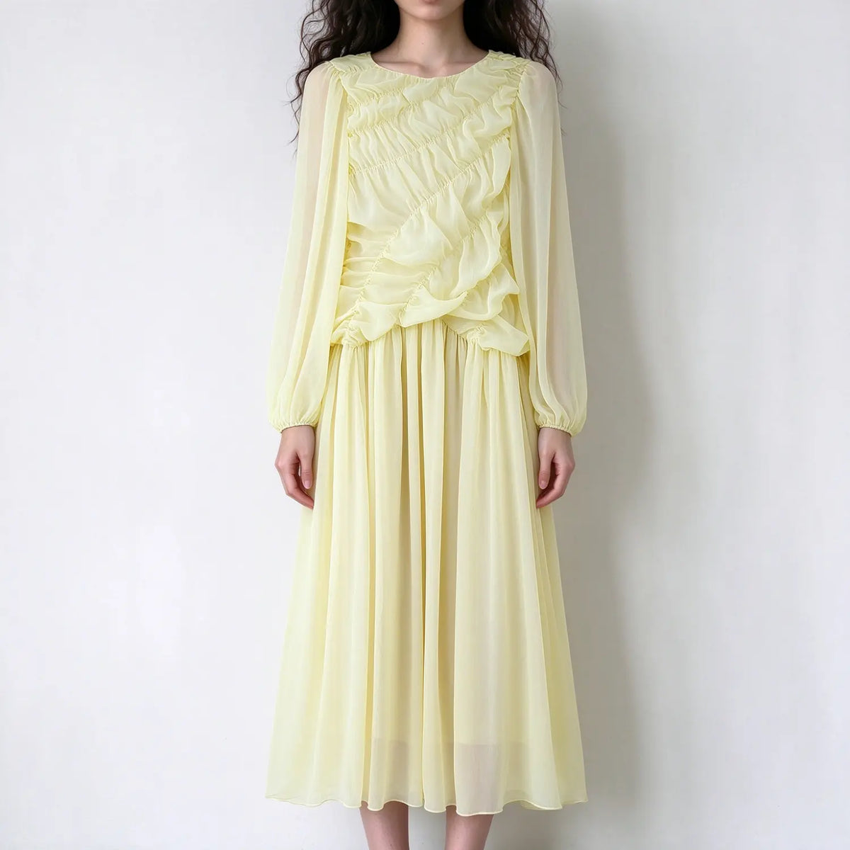 Model wearing pale yellow ruffled chiffon maxi dress, long sheer balloon sleeves, ruched ruffle bodice, loose flowy maxi skirt, plain white background