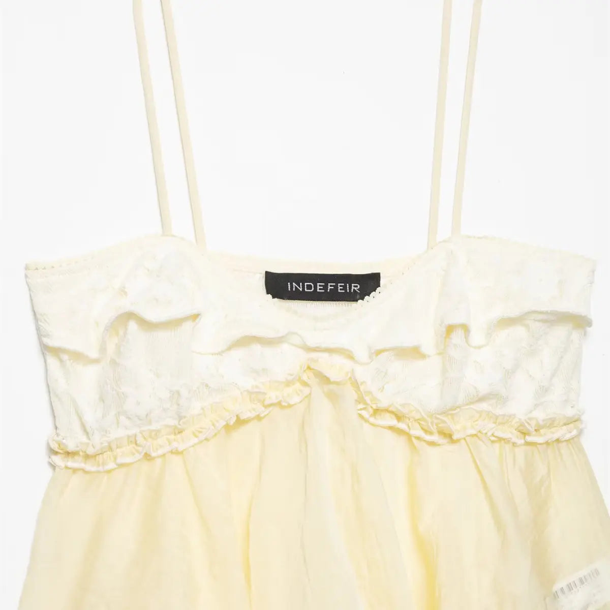 Front view of pale yellow ruffled camisole, featuring the lace bodice, thin straps, and brand label