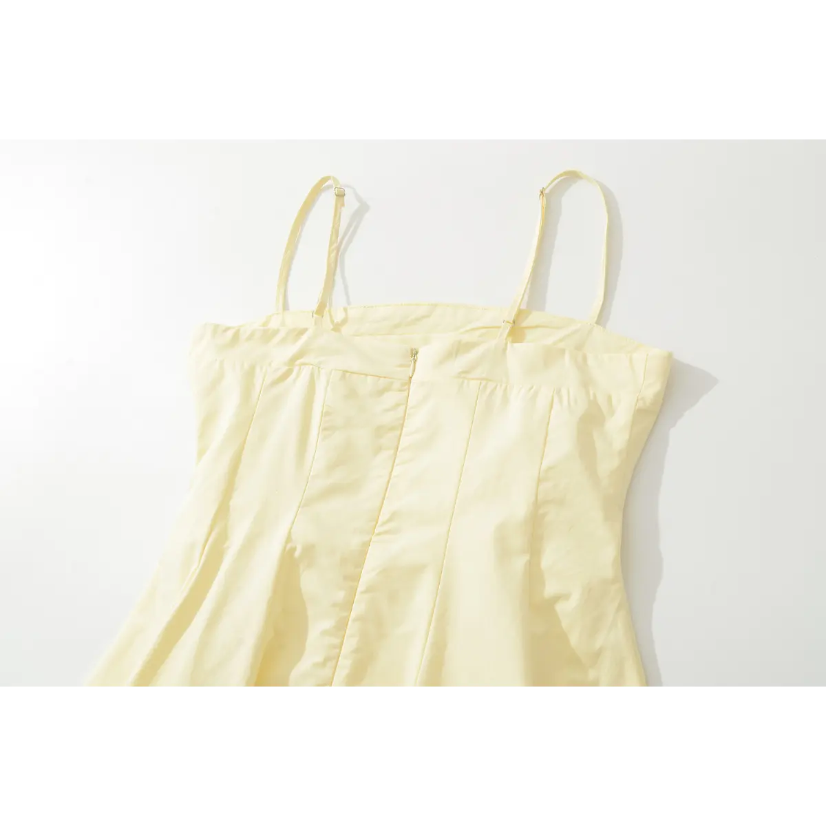 Back view of the dress's upper section, highlighting the center zipper, princess seams, and adjustable spaghetti straps.